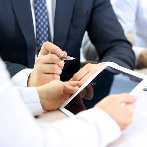 Business meeting with tablet and charts.