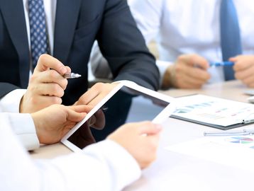 A physician and executive viewing an iPad. 