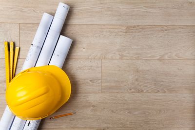 Hard hat and blueprints are some of the tools used for fire protection design and installation.
