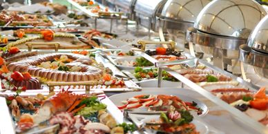 A lavish buffet with various dishes and chafing dishes in the background.