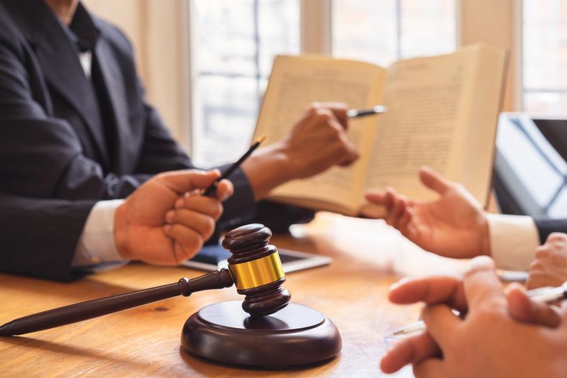 Legal professionals discussing a case with a gavel on the table.