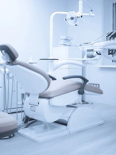 Modern dental chair in a clean, bright clinic room.
