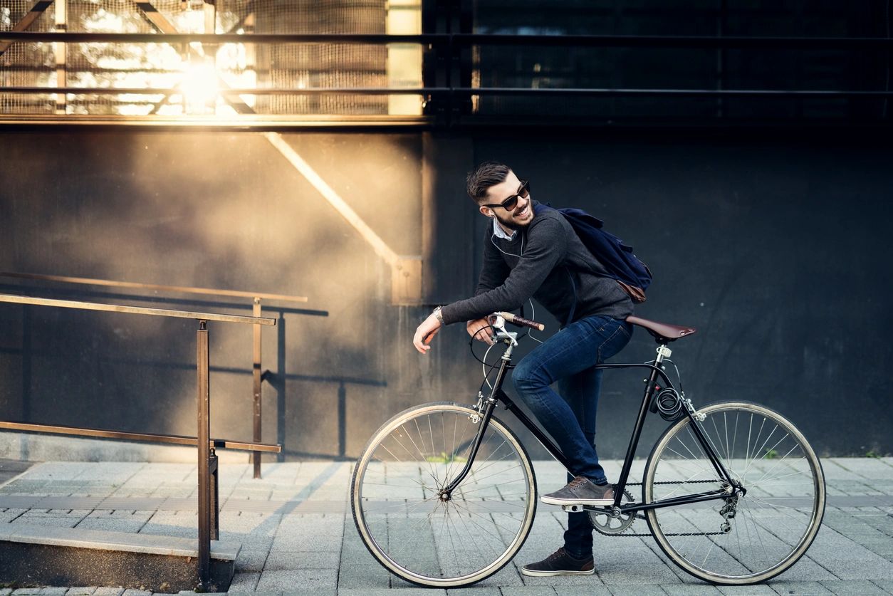 Man with a bicycle in urban setting.