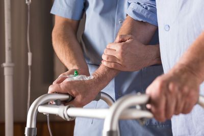 An aide helping a patient with walking