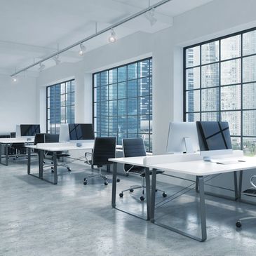 Modern office with large windows and sleek workstations.