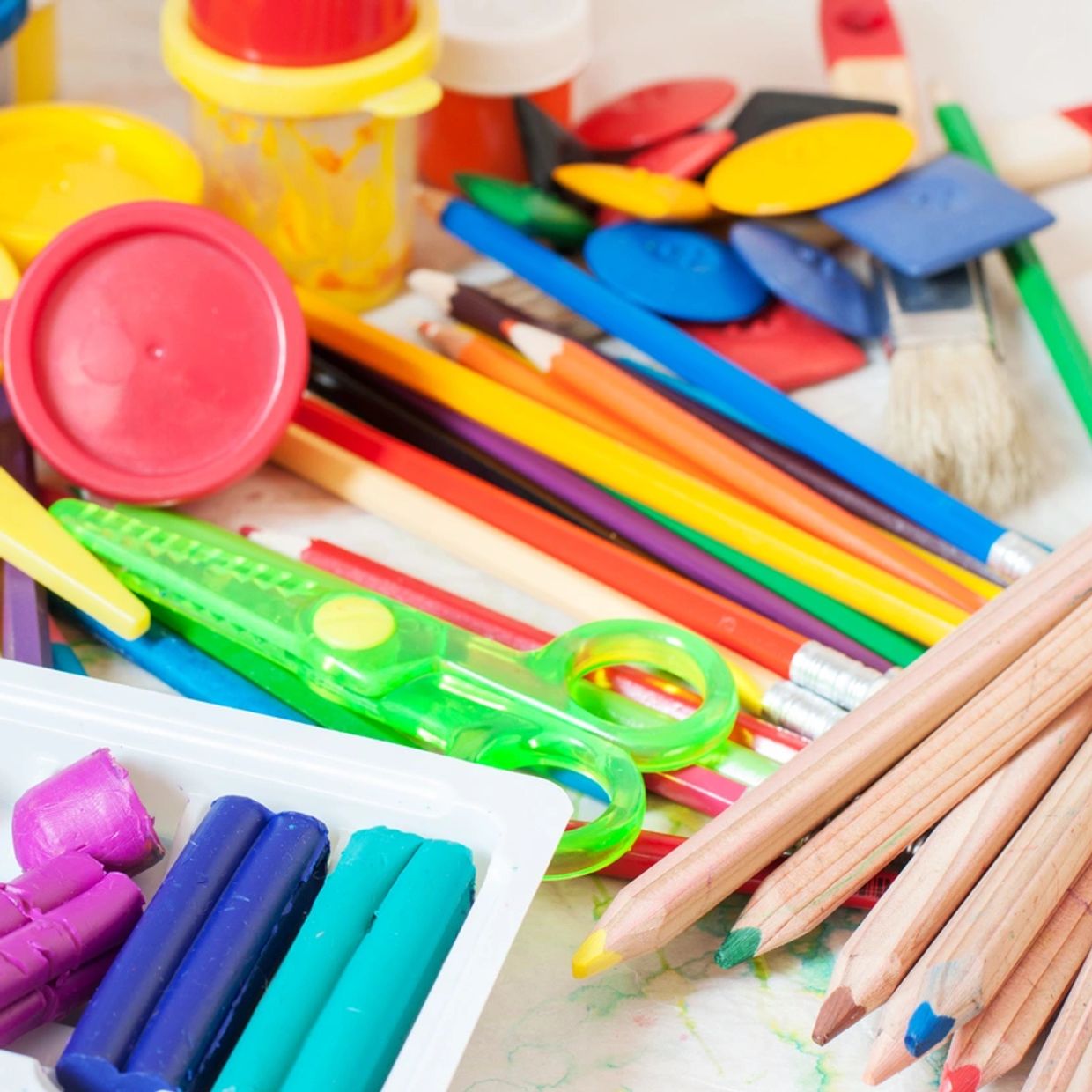 Colorful art supplies including pencils, crayons, and scissors.