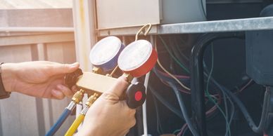Technician diagnosing a heating and cooling system with guages