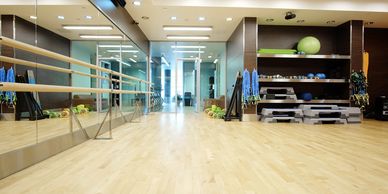 Modern gym with mirrored wall and workout equipment.