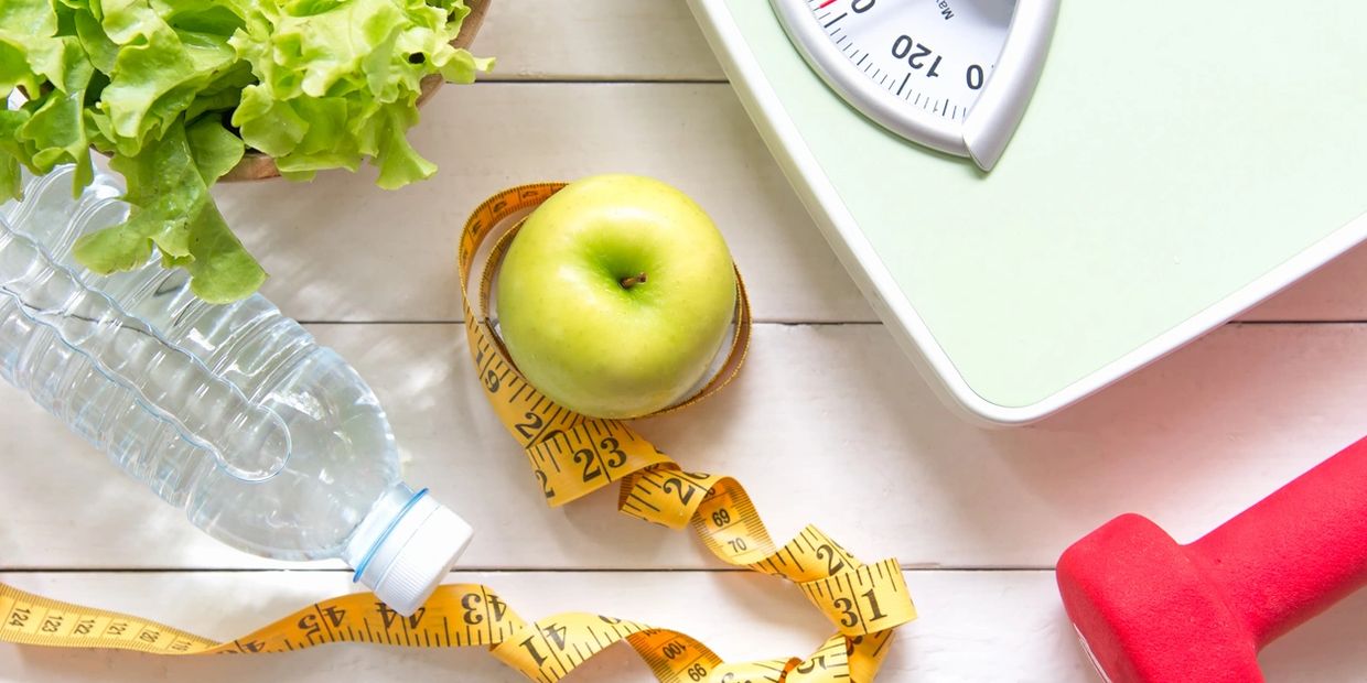 Scale with weight loss tape around an apple