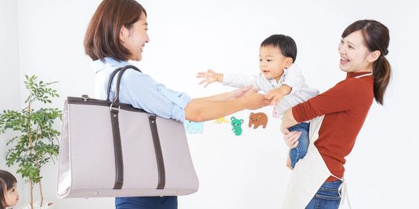 This is an Asian mom coming home from a long day and happily receiving her baby from her Asian nanny