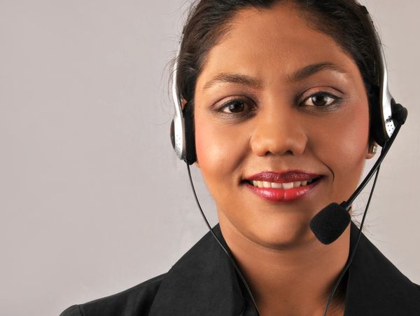 Smiling woman wearing a headset and black jacket.
