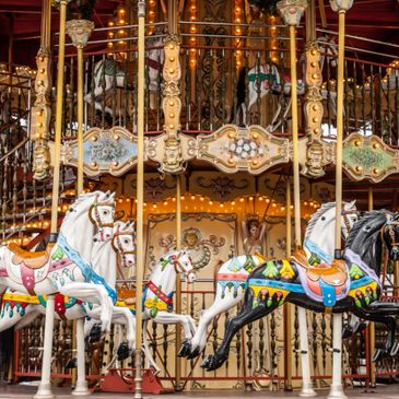 Colorful carousel horses with intricate designs on a vintage merry-go-round.