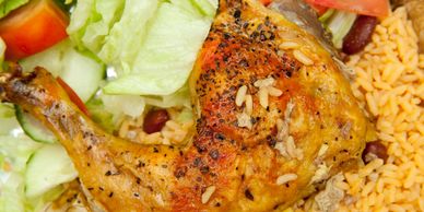 Grilled chicken leg served with rice and fresh salad.
