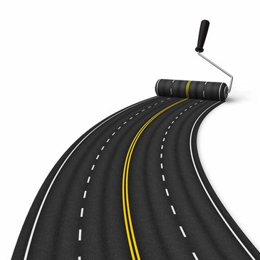 A paint roller painting a road with lane markings.