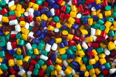 Colorful plastic bottle caps scattered closely together in various colors.