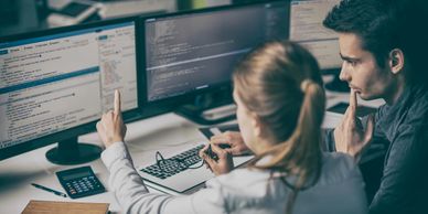 A woman showing a man data on her computer