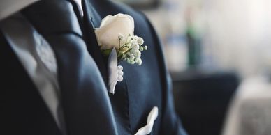 Close-up of a groom's suit with a white rose boutonniere.