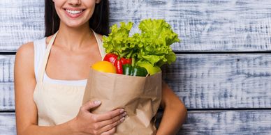 a woman holding a bag of vegetables 