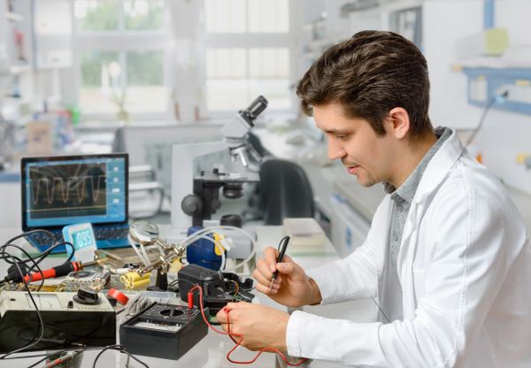 Scientist working with electronic equipment in a lab.