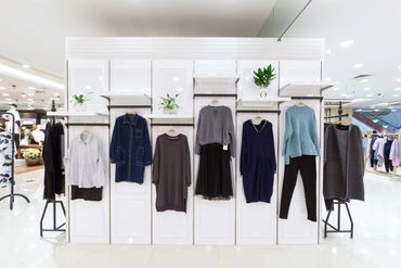 A fashion display of women's clothing in a bright store.