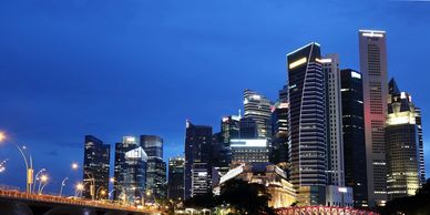 City skyline with illuminated modern skyscrapers at dusk.
