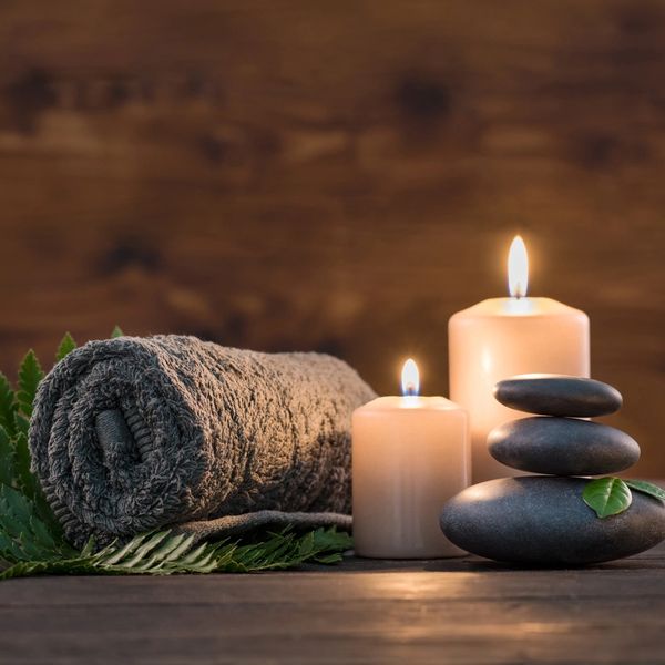 A towel, candles and stacked rocks