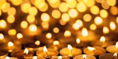 Rows of lit tea candles in warm light.