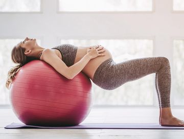 An image of a pregnant woman exercising on an therapy ball.