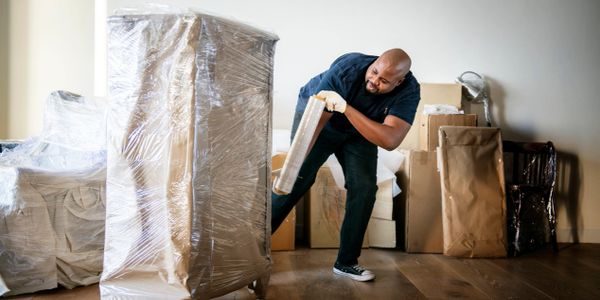 Movers wrapping furniture