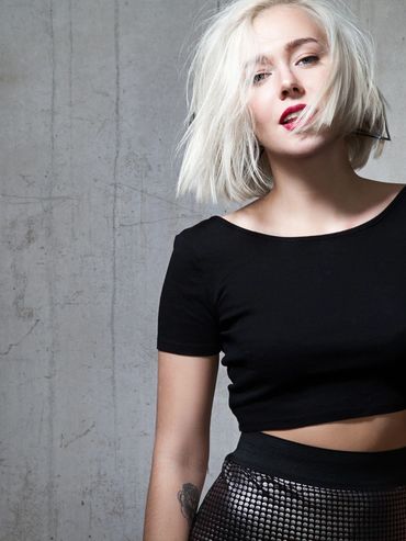 Young woman with platinum blonde hair and black outfit.