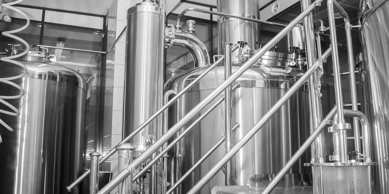 Stainless steel tanks and pipes inside a modern industrial facility.