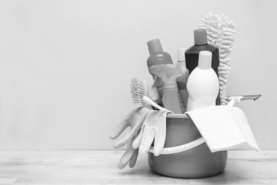 Cleaning supplies including spray bottles, gloves, and brushes in a bucket.
