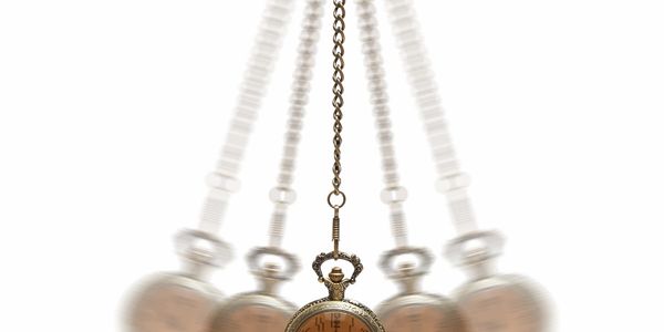 Swinging antique pocket watch on a chain, showing motion blur