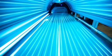 Inside a blue tanning bed with UV lights.