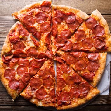 A pepperoni pizza sliced into eight pieces on a wooden surface.