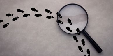 Image of private investigator footprints and a magnifying glass often associated with investigations