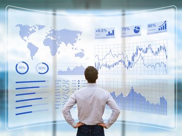 Man analyzing global data and financial charts on a futuristic transparent screen.