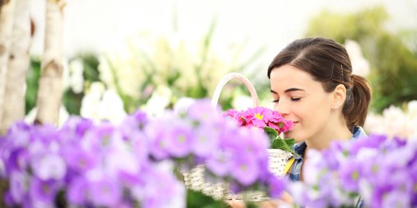 girl smelling flowers in a garden