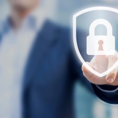 Businessman interacts with virtual security lock icon symbolizing cybersecurity.