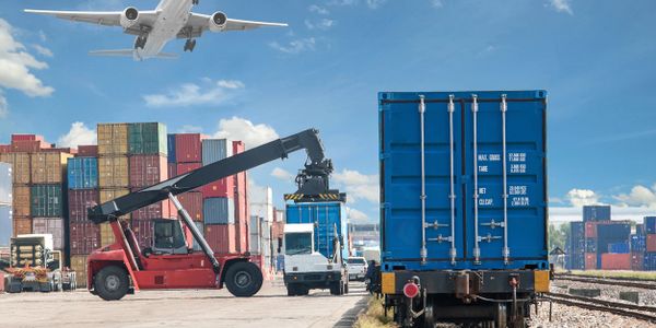 Cargo containers being loaded and transported at a busy port.