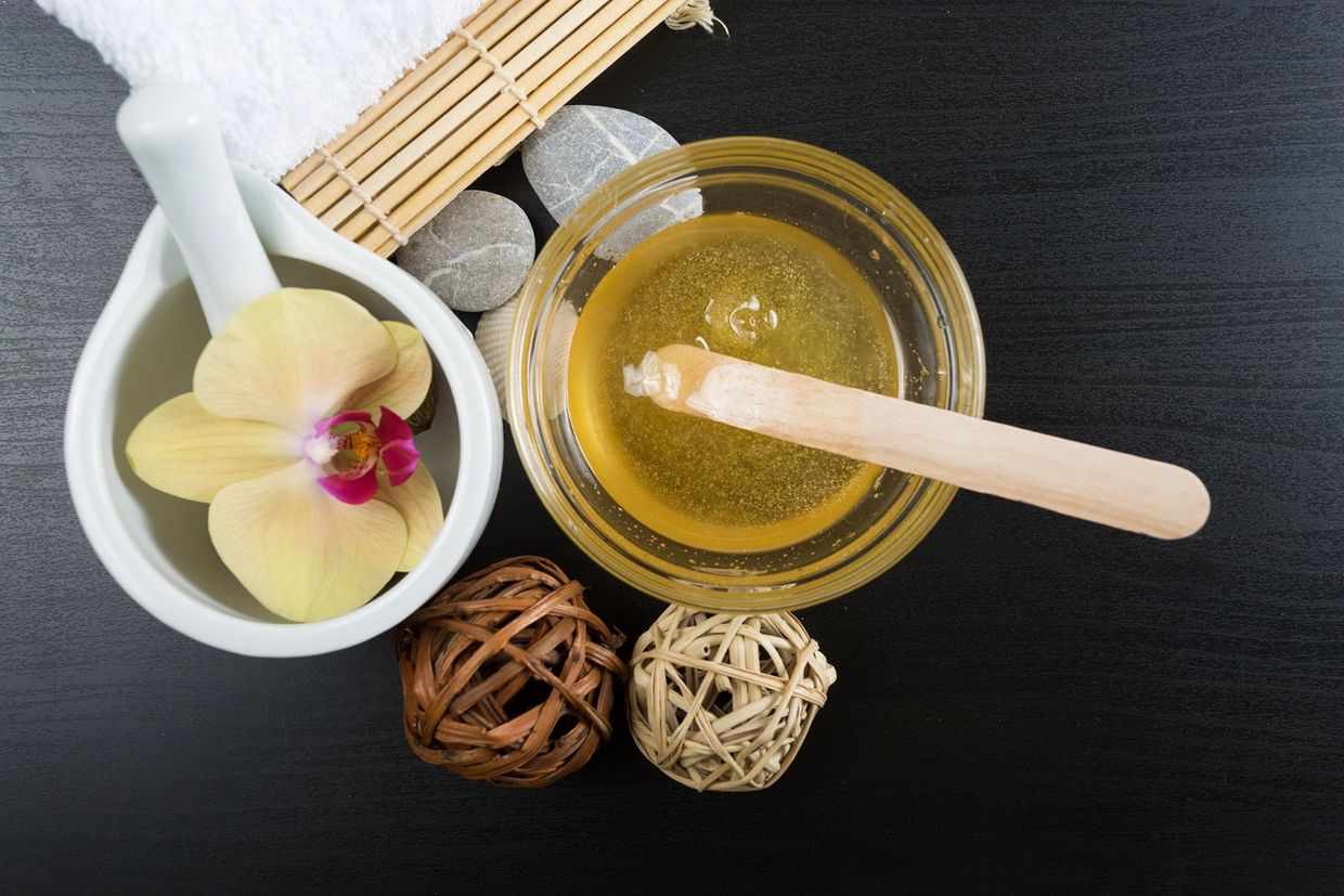 Honey soft wax in a cup on a table with a flower decorations