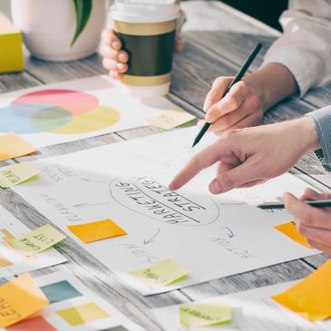 People brainstorming and planning a marketing strategy with notes and charts.