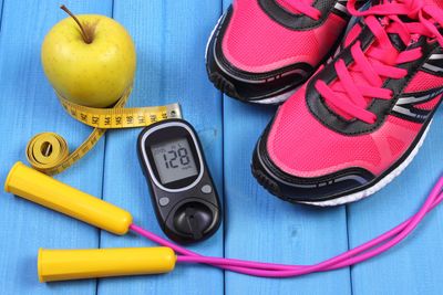 Fitness and health tools including a glucose meter, skipping rope, apple, and running shoes.