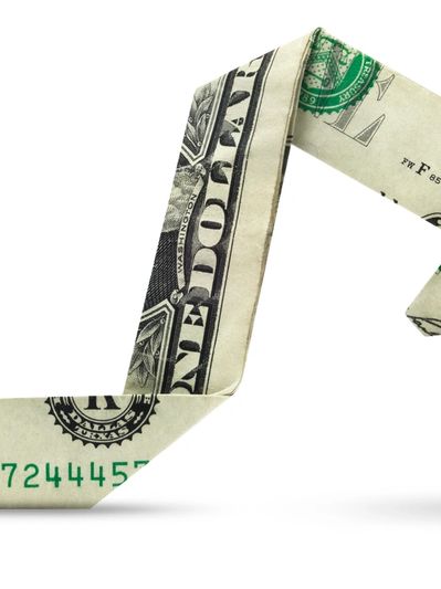 A dollar bill folded into the shape of an upward arrow.