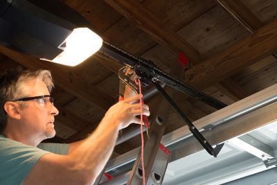 garage door technician repairing garage operator.