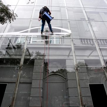 Man cleaning large glass building