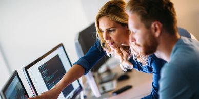 man and woman looking at computer screen