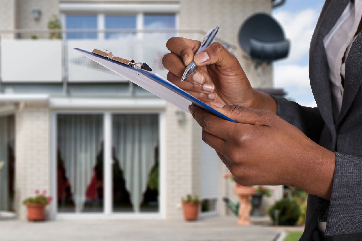 An appraiser makes notes on her clipboard.