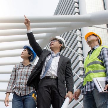 Engineers and architect discussing a construction project outdoors.