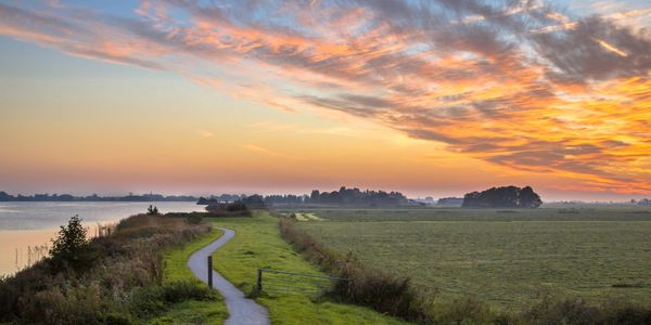 Pathway running along the sea with sunset